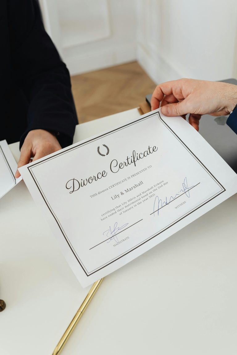Overhead view of hands exchanging a divorce certificate in a professional environment.